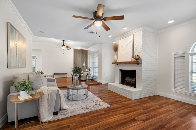 living room with a fireplace, ceiling fan, dark hardwood / wood-style floors, and plenty of natural light