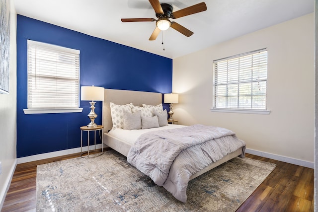 bedroom with ceiling fan, dark hardwood / wood-style flooring, and multiple windows