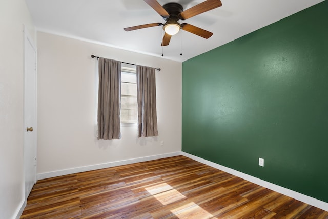 empty room with ceiling fan and hardwood / wood-style flooring