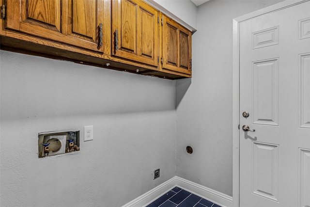 laundry room with washer hookup, cabinets, dark tile patterned flooring, and electric dryer hookup