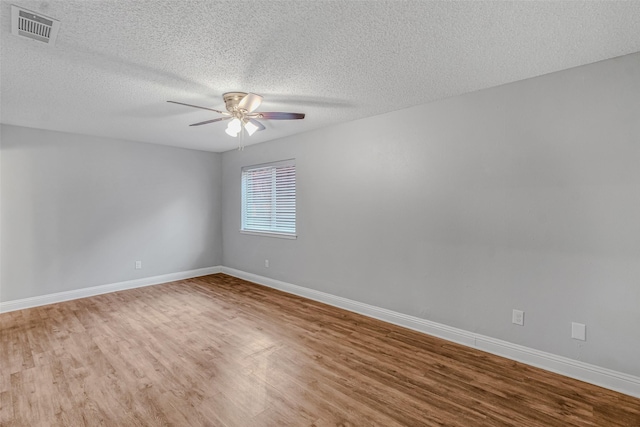 spare room with ceiling fan, a textured ceiling, and hardwood / wood-style floors