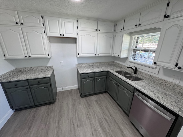 kitchen featuring white cabinetry, dishwasher, sink, light hardwood / wood-style floors, and a textured ceiling