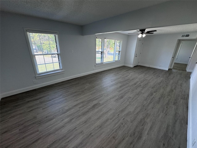 unfurnished room featuring ceiling fan, dark wood-type flooring, and a textured ceiling