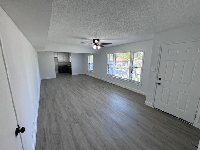 unfurnished living room with ceiling fan, hardwood / wood-style flooring, and a textured ceiling