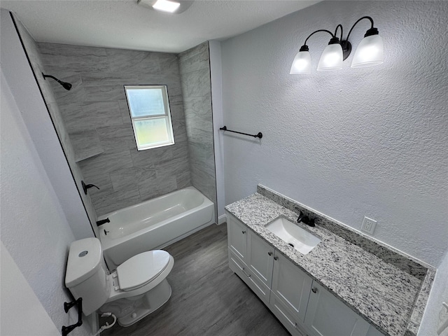 full bathroom with hardwood / wood-style flooring, vanity, toilet, and tiled shower / bath