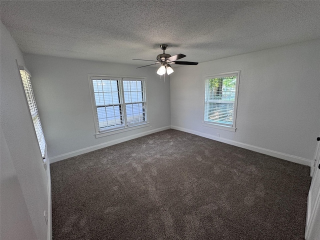 empty room featuring ceiling fan, a textured ceiling, and dark colored carpet