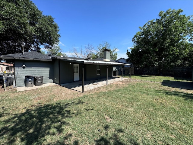 back of property with a patio and a yard