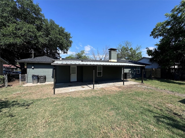 back of property with a patio area and a lawn