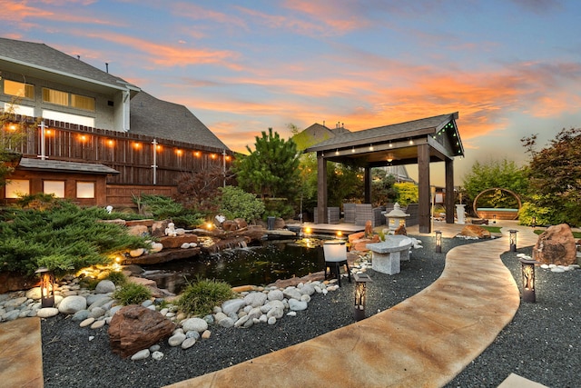 yard at dusk featuring a patio area and an outdoor fire pit