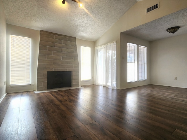 unfurnished living room with a fireplace, hardwood / wood-style flooring, vaulted ceiling, and plenty of natural light