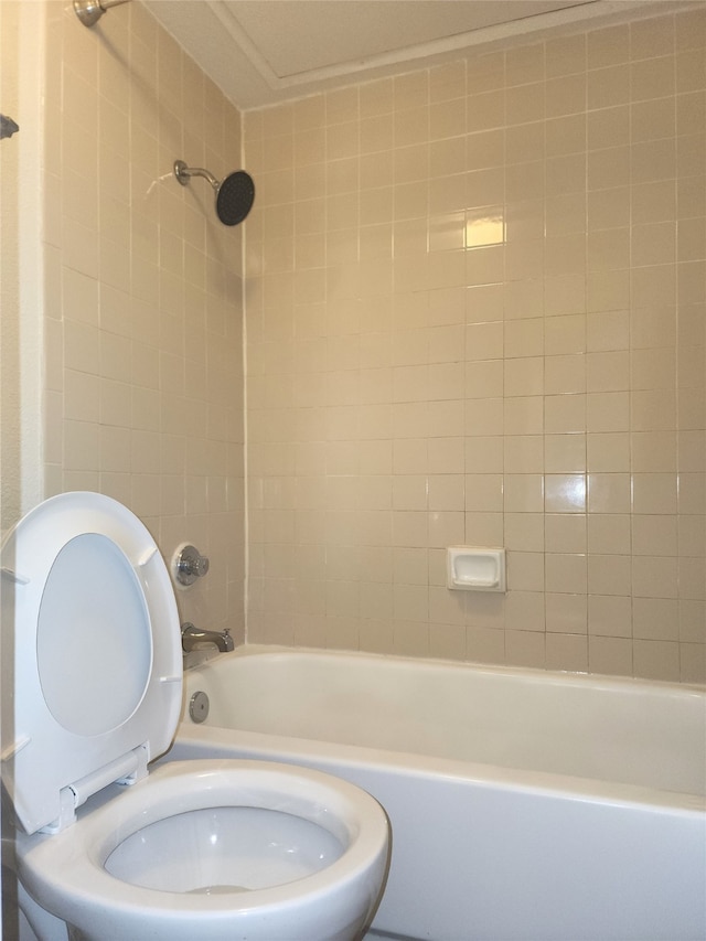 bathroom featuring tiled shower / bath combo and toilet