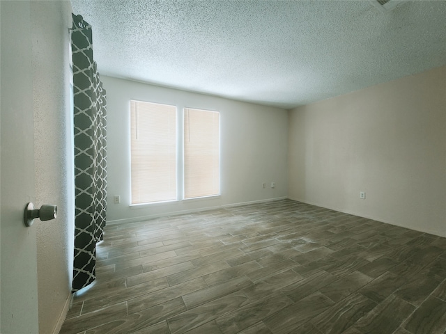 spare room with hardwood / wood-style floors and a textured ceiling