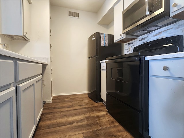 kitchen with white cabinetry, dark hardwood / wood-style flooring, range with electric cooktop, and black refrigerator