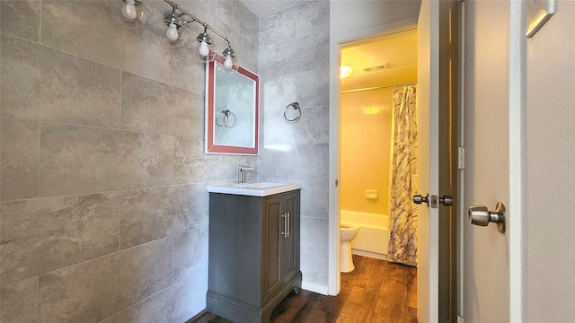 full bathroom with shower / bath combo with shower curtain, wood-type flooring, toilet, and vanity