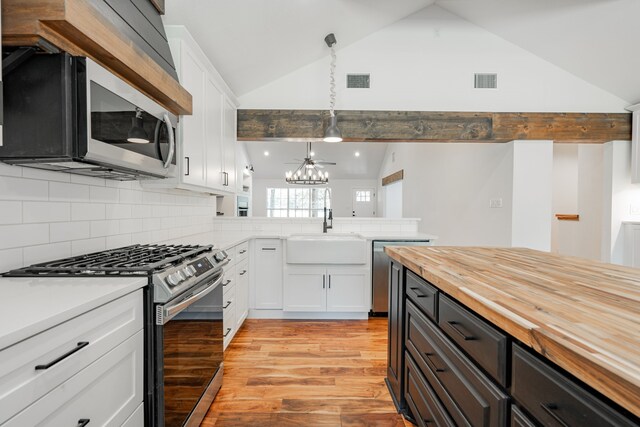 kitchen featuring white cabinetry, hardwood / wood-style floors, beamed ceiling, butcher block countertops, and a kitchen island