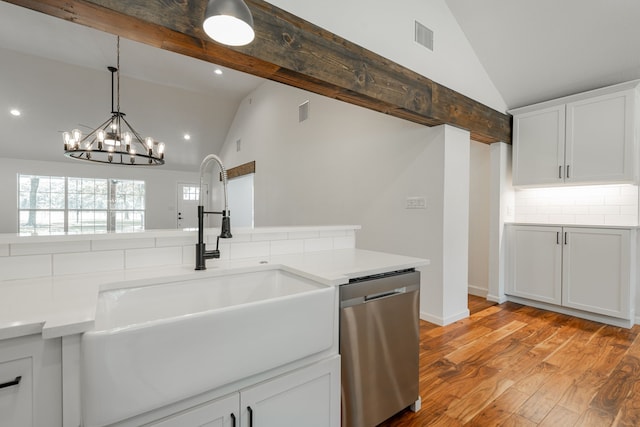 kitchen featuring decorative light fixtures, stainless steel dishwasher, high vaulted ceiling, sink, and light hardwood / wood-style flooring