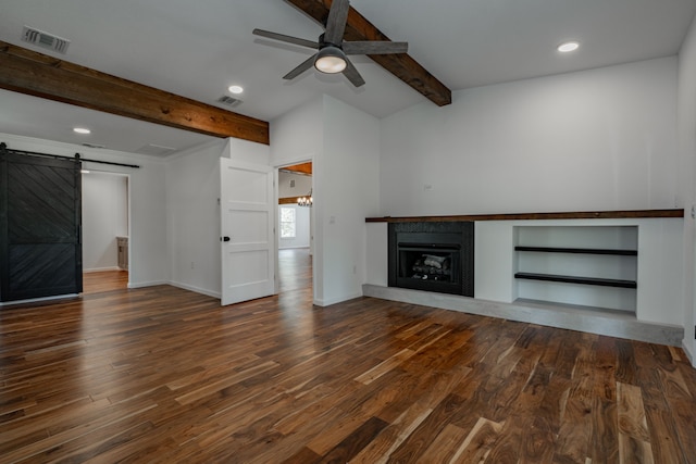 unfurnished living room featuring lofted ceiling with beams, a barn door, hardwood / wood-style flooring, and ceiling fan