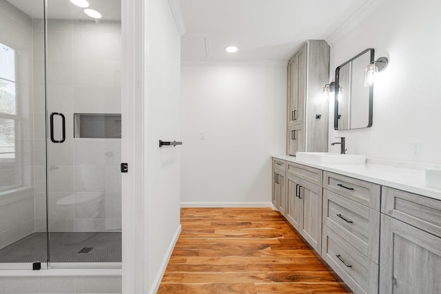 bathroom featuring hardwood / wood-style flooring, an enclosed shower, vanity, and ornamental molding