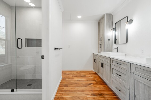 bathroom with double vanity, crown molding, and hardwood / wood-style flooring