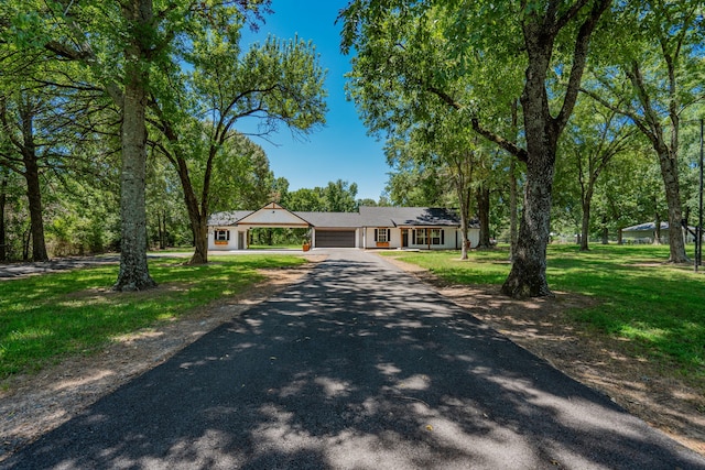 ranch-style house with a front yard and a garage