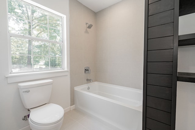 bathroom featuring tile patterned flooring, tiled shower / bath combo, toilet, and a healthy amount of sunlight