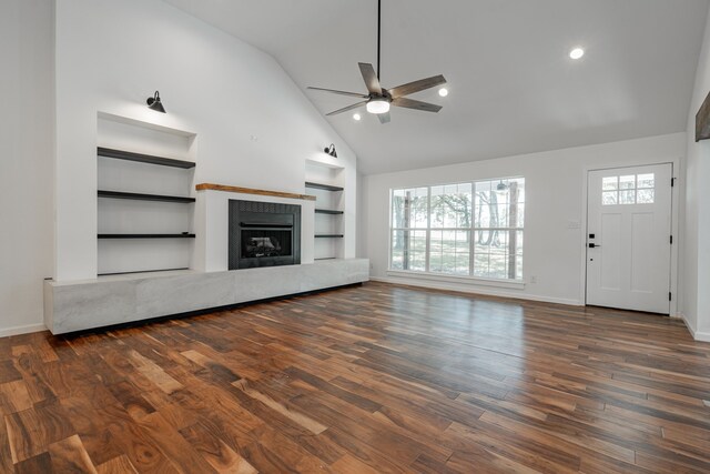 unfurnished living room with ceiling fan, high vaulted ceiling, and dark wood-type flooring