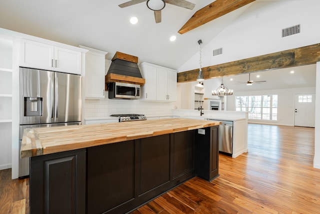 kitchen with a kitchen island, ceiling fan with notable chandelier, light hardwood / wood-style floors, and butcher block counters