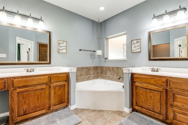 bathroom with a washtub, tile patterned floors, and vanity