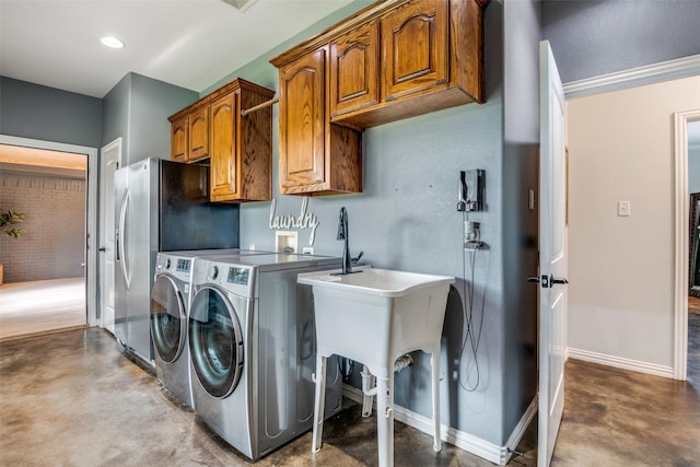 laundry area with separate washer and dryer and cabinets