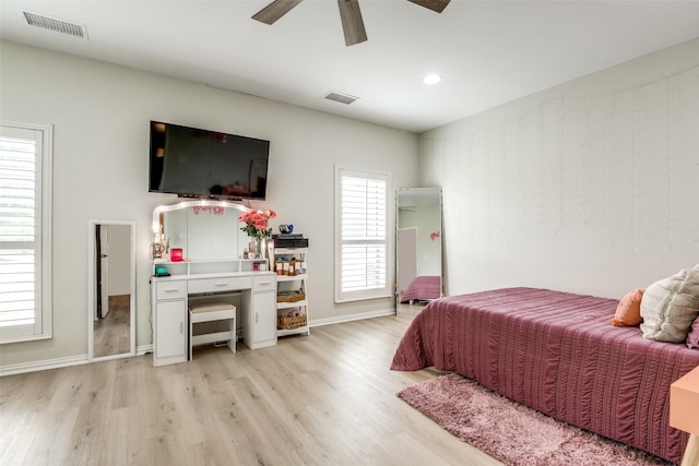 bedroom with light hardwood / wood-style floors, multiple windows, and ceiling fan