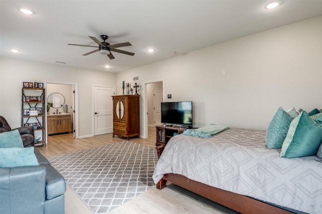 bedroom with ceiling fan, hardwood / wood-style floors, and ensuite bath