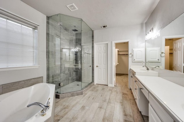 bathroom with hardwood / wood-style flooring, a textured ceiling, vanity, and separate shower and tub