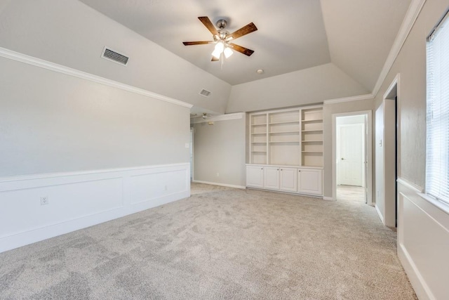 interior space featuring ceiling fan, lofted ceiling, crown molding, and light carpet