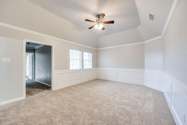 carpeted spare room featuring ceiling fan, ornamental molding, a raised ceiling, and vaulted ceiling