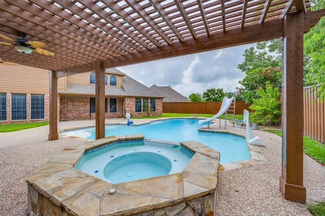 view of swimming pool with an in ground hot tub, a patio area, a water slide, and a pergola