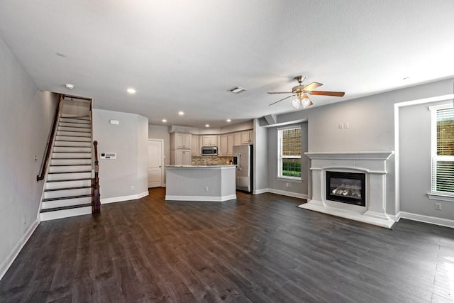 unfurnished living room featuring dark hardwood / wood-style floors and ceiling fan