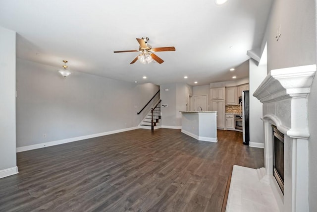 unfurnished living room featuring dark hardwood / wood-style floors and ceiling fan