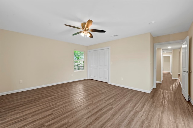 unfurnished bedroom with ceiling fan, wood-type flooring, and a closet