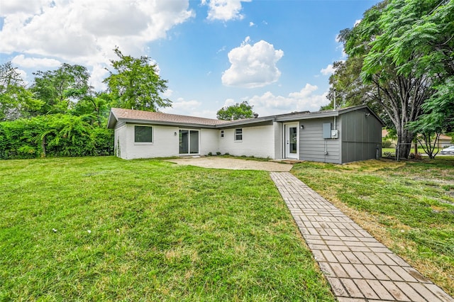 back of house featuring a patio area and a lawn