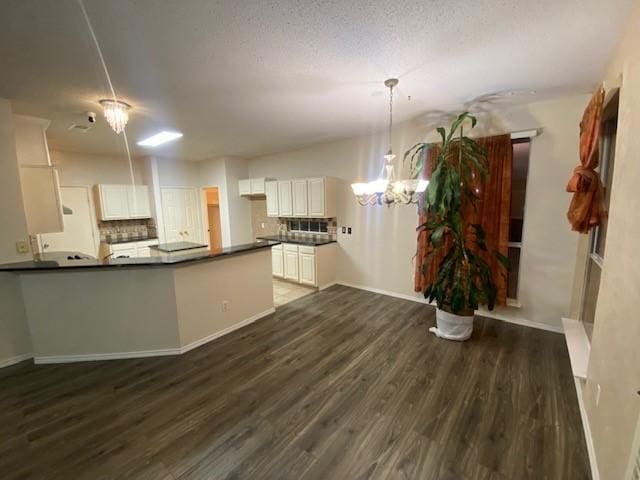 kitchen with decorative backsplash, dark hardwood / wood-style flooring, a textured ceiling, pendant lighting, and white cabinetry