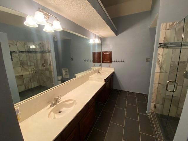 bathroom with tile patterned floors, vanity, and a shower with door