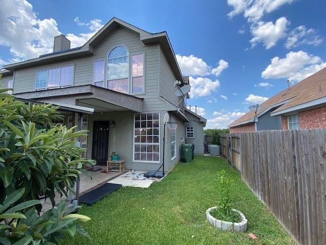 back of property with a patio area and a yard