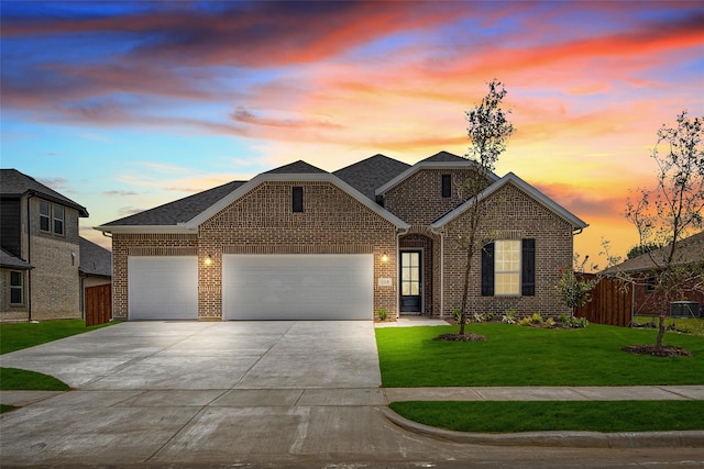 view of front of home with a garage and a lawn