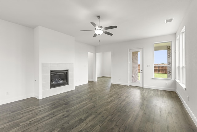 unfurnished living room with dark wood-type flooring, ceiling fan, and a fireplace