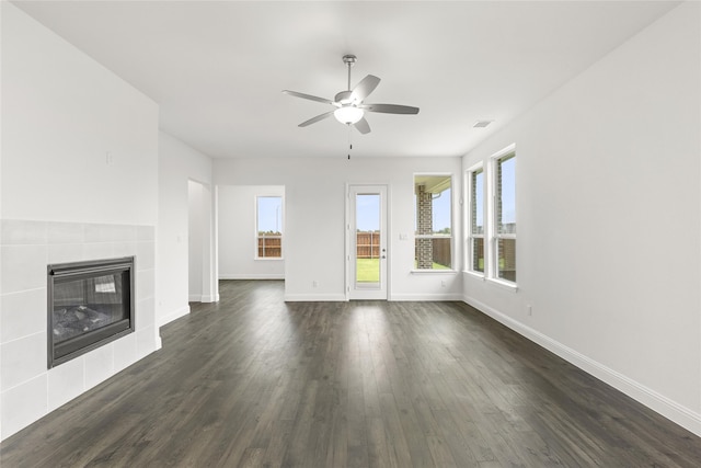 unfurnished living room with a fireplace, ceiling fan, and dark wood-type flooring