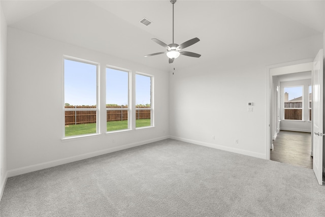 carpeted empty room featuring a healthy amount of sunlight and ceiling fan