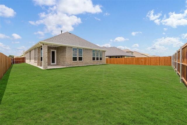 rear view of house with a patio and a yard