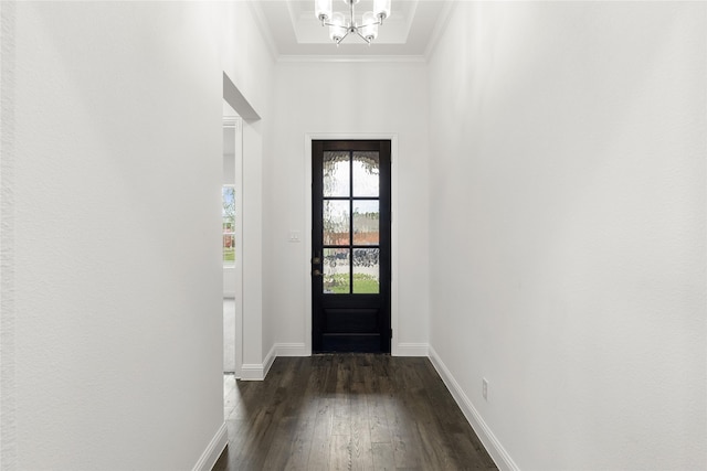 doorway with dark hardwood / wood-style flooring, a notable chandelier, and crown molding