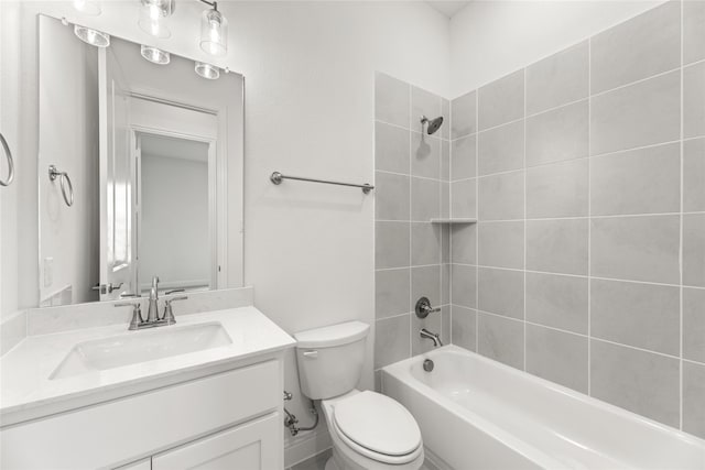 full bathroom featuring vanity, tiled shower / bath, and toilet