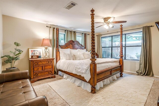 carpeted bedroom with multiple windows and ceiling fan